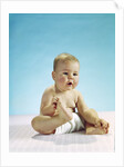1960s baby sitting holding on to his feet by Anonymous