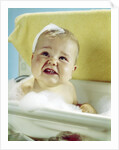 1960s smiling baby in bath looking up by Anonymous