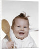 1960s 1970s smiling baby wearing bib and holding wooden spoon by Anonymous