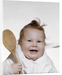 1960s 1970s smiling baby wearing bib and holding wooden spoon by Anonymous