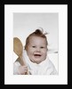 1960s 1970s smiling baby wearing bib and holding wooden spoon by Anonymous