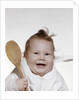 1960s 1970s smiling baby wearing bib and holding wooden spoon by Anonymous