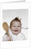 1960s 1970s smiling baby wearing bib and holding wooden spoon by Anonymous