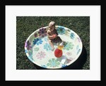 1970s baby sitting in plastic backyard kiddy pool viewed from above by Anonymous