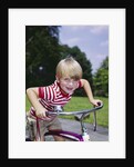 1970s 1960s smiling blond boy leaning over handlebars of bicycle looking at camera by Anonymous