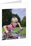 1970s 1960s smiling blond boy leaning over handlebars of bicycle looking at camera by Anonymous