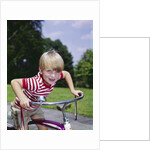 1970s 1960s smiling blond boy leaning over handlebars of bicycle looking at camera by Anonymous