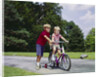 1960s 1970s boy helping little brother ride two wheel bicycle with training wheels by Anonymous