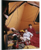 1960s father with lantern checking up on 3 boys in sleeping bags pajamas in tent by Anonymous