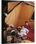 1960s father with lantern checking up on 3 boys in sleeping bags pajamas in tent by Anonymous