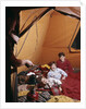 1960s father with lantern checking up on 3 boys in sleeping bags pajamas in tent by Anonymous