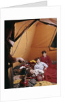 1960s father with lantern checking up on 3 boys in sleeping bags pajamas in tent by Anonymous