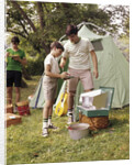 1960s three boys at campsite cooking camp stove eating food tent teens by Anonymous