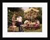 1970s group teenagers boys girls backyard grilling table umbrella by Anonymous