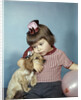 1950s 1960s little girl wearing party hat frowning hugging a cocker spaniel puppy by Anonymous