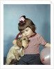 1950s 1960s little girl wearing party hat frowning hugging a cocker spaniel puppy by Anonymous