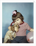 1950s 1960s little girl wearing party hat frowning hugging a cocker spaniel puppy by Anonymous