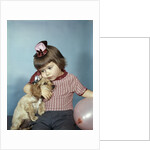 1950s 1960s little girl wearing party hat frowning hugging a cocker spaniel puppy by Anonymous