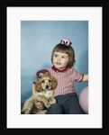 1950s 1960s little girl in party hat sitting holding a cocker spaniel puppy by Anonymous