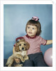 1950s 1960s little girl in party hat sitting holding a cocker spaniel puppy by Anonymous