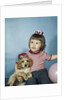 1950s 1960s little girl in party hat sitting holding a cocker spaniel puppy by Anonymous
