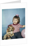 1950s 1960s little girl in party hat sitting holding a cocker spaniel puppy by Anonymous