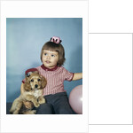 1950s 1960s little girl in party hat sitting holding a cocker spaniel puppy by Anonymous