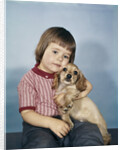 1950s 1960s winsome sad little girl sitting hugging a cocker spaniel puppy studio by Anonymous