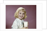 1960s girl glass milk dairy smile looking at camera by Anonymous