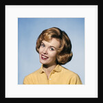 1960s smiling blond woman wearing a yellow sweater head tilted quizzical expression by Anonymous