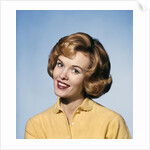 1960s smiling blond woman wearing a yellow sweater head tilted quizzical expression by Anonymous