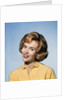 1960s smiling blond woman wearing a yellow sweater head tilted quizzical expression by Anonymous