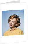 1960s smiling blond woman wearing a yellow sweater head tilted quizzical expression by Anonymous