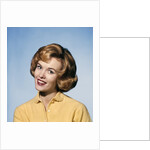 1960s smiling blond woman wearing a yellow sweater head tilted quizzical expression by Anonymous