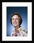 1960s smiling woman in white print dress looking up studio by Anonymous
