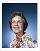 1960s smiling woman in white print dress looking up studio by Anonymous