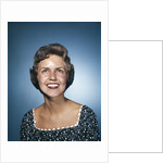 1960s smiling brunette woman in print dress looking up by Anonymous