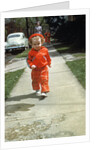 1950s little boy in red outfit running on pavement with mother just behind by Anonymous