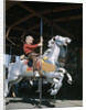 1950s excited boy riding carved wooden carousel merry-go-round horse by Anonymous