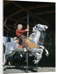 1950s excited boy riding carved wooden carousel merry-go-round horse by Anonymous