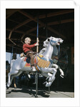 1950s excited boy riding carved wooden carousel merry-go-round horse by Anonymous