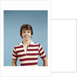 1970s portrait of smiling teenage boy wearing striped rugby shirt looking at camera by Anonymous