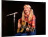1970s blond young woman ponytails plaid shirt jeans play guitar singing microphone folk singer singers by Anonymous