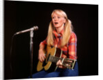 1970s blond young woman ponytails plaid shirt jeans play guitar singing microphone folk singer singers by Anonymous