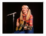 1970s blond young woman ponytails plaid shirt jeans play guitar singing microphone folk singer singers by Anonymous