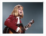 1960s blond teenaged girl singing and playing acoustic guitar by Anonymous