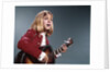1960s blond teenaged girl singing and playing acoustic guitar by Anonymous