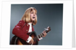 1960s blond teenaged girl singing and playing acoustic guitar by Anonymous
