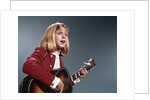 1960s blond teenaged girl singing and playing acoustic guitar by Anonymous