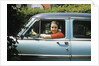 1950s woman driver looking out of car window by Anonymous